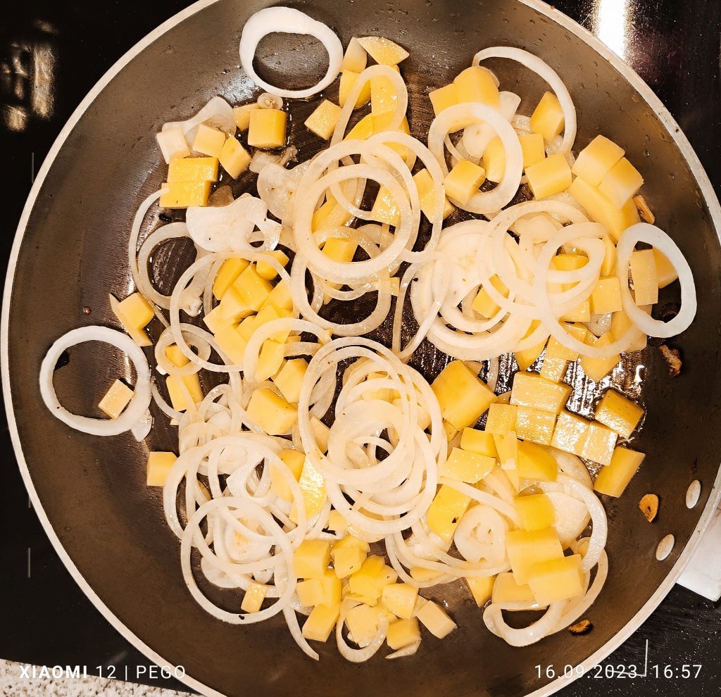 Zwiebel und Kartoffelwürfel in Butterschmalz glasig anbraten